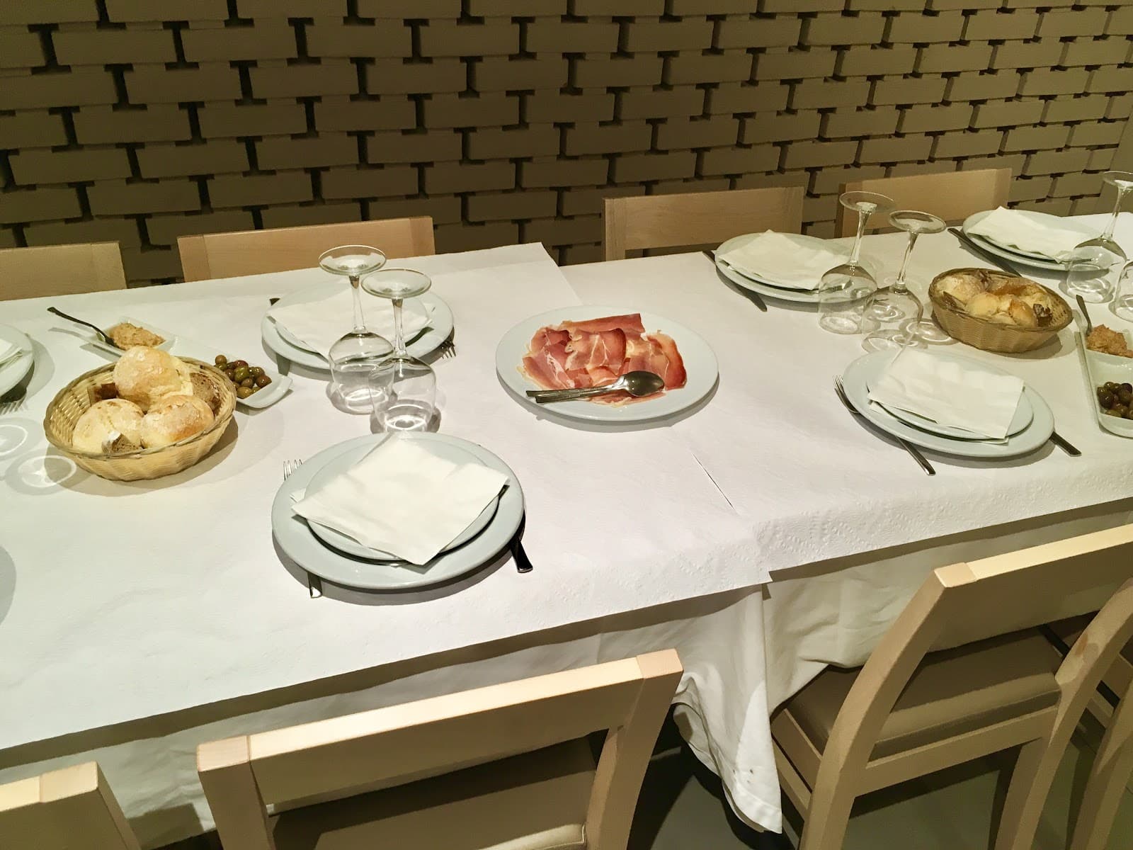 Mesa posta com presunto, pão e azeitonas